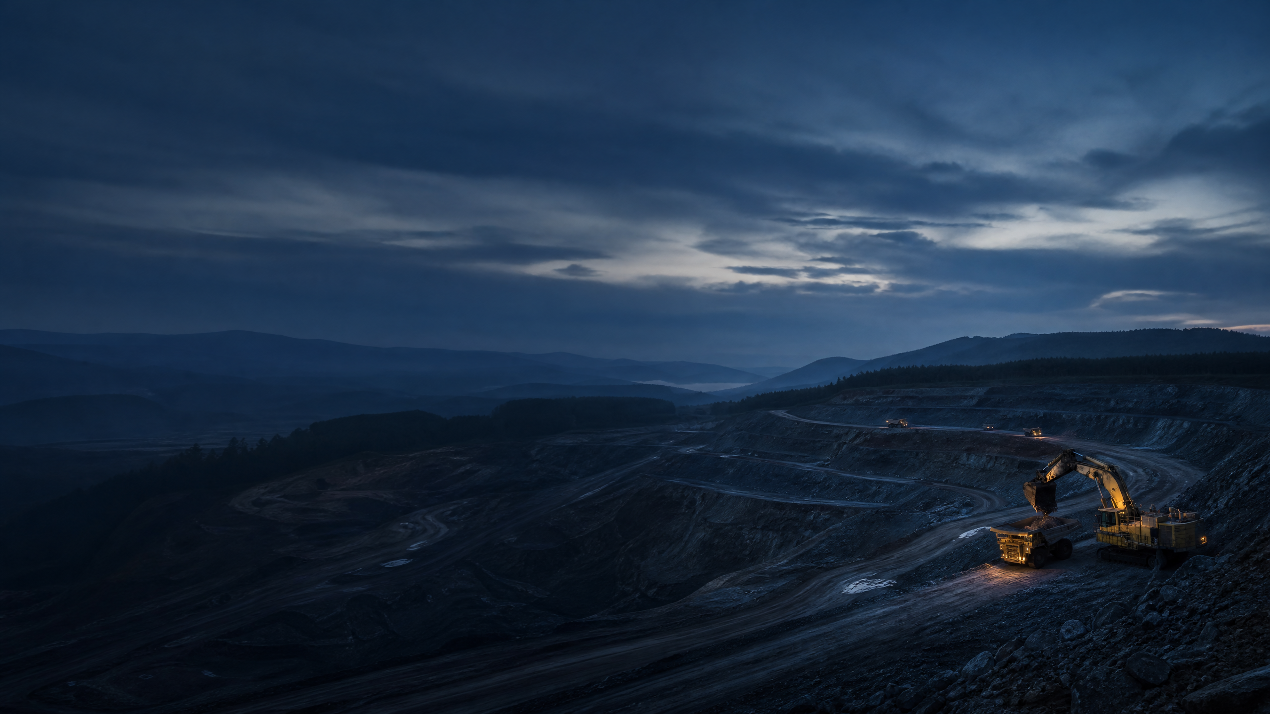 Terraced surface mining operation at blue hour.